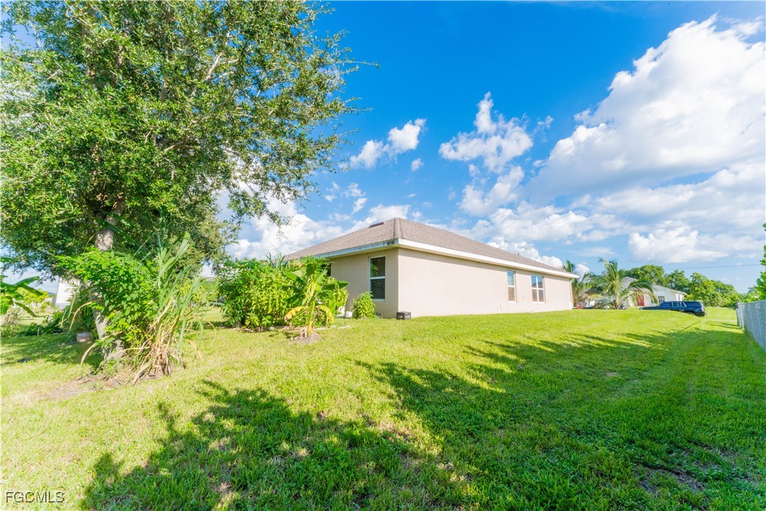 5134 Baron Street Lehigh Acres, FL 33971 - Photo 16 of 30 a big yard with potted plants in front of it