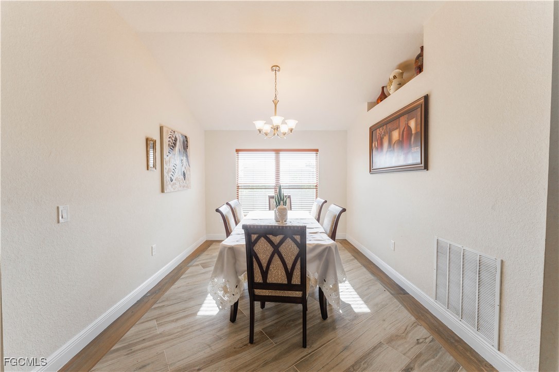 5134 Baron Street Lehigh Acres, FL 33971 - Photo 3 of 30 a view of a dining room with furniture window and wooden floor