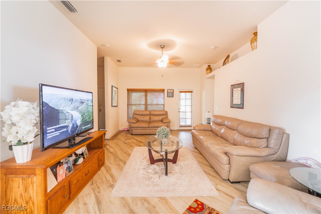 5134 Baron Street Lehigh Acres, FL 33971 - Photo 5 of 30 a living room with furniture and a flat screen tv