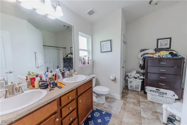 a bathroom with a sink vanity mirror and toilet