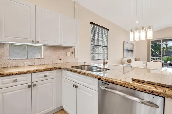 a kitchen with granite countertop white cabinets and white appliances