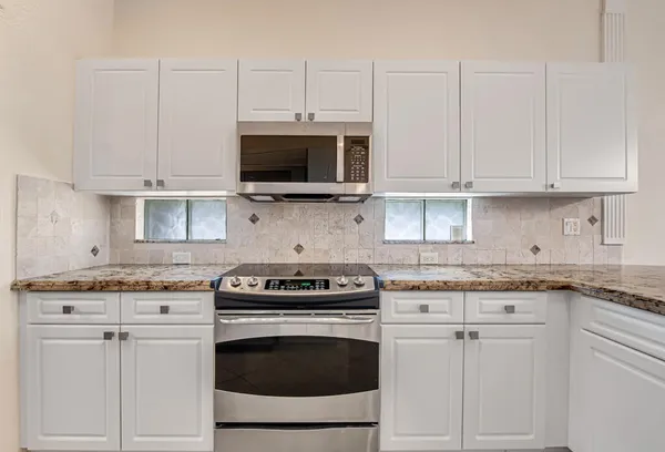 a kitchen with cabinets stainless steel appliances and a sink