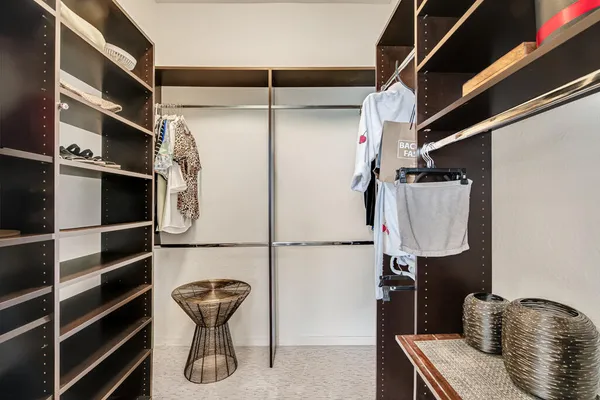 a view of walk in closet with clothes and shoes