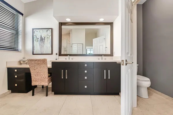 a bathroom with a granite countertop sink a toilet and a mirror