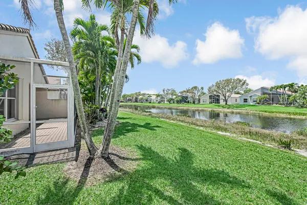 a couple of palm trees in front of a house with a garden