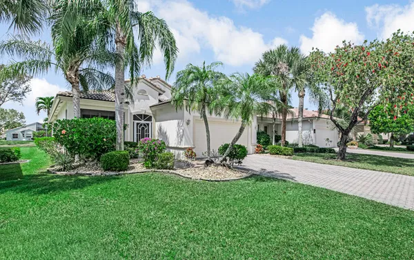 a view of a house with a yard and palm trees