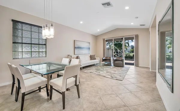 a dining room with furniture and large windows