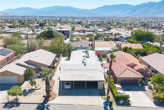 an aerial view of a house with a garden and lake view