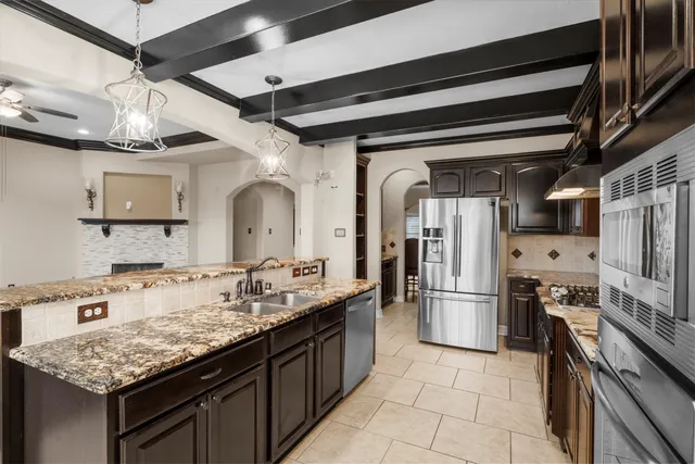 a kitchen with stainless steel appliances granite countertop a sink refrigerator and cabinets