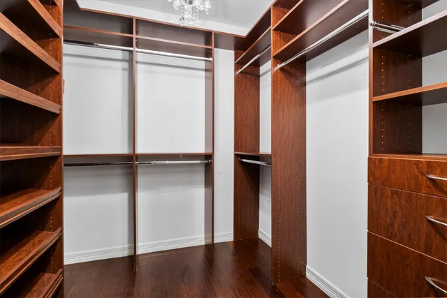 a view of walk in closet with wooden floor