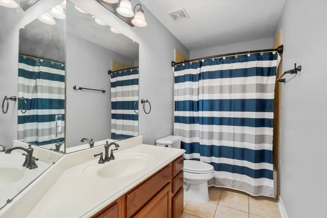 a bathroom with a sink a toilet a shower and a mirror