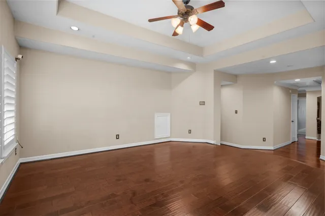 an empty room with wooden floor closet and fan