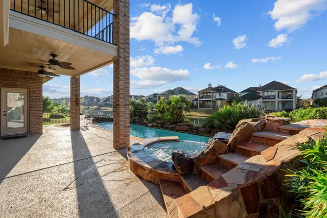 a view of a patio with couches table and chairs with wooden floor and fence