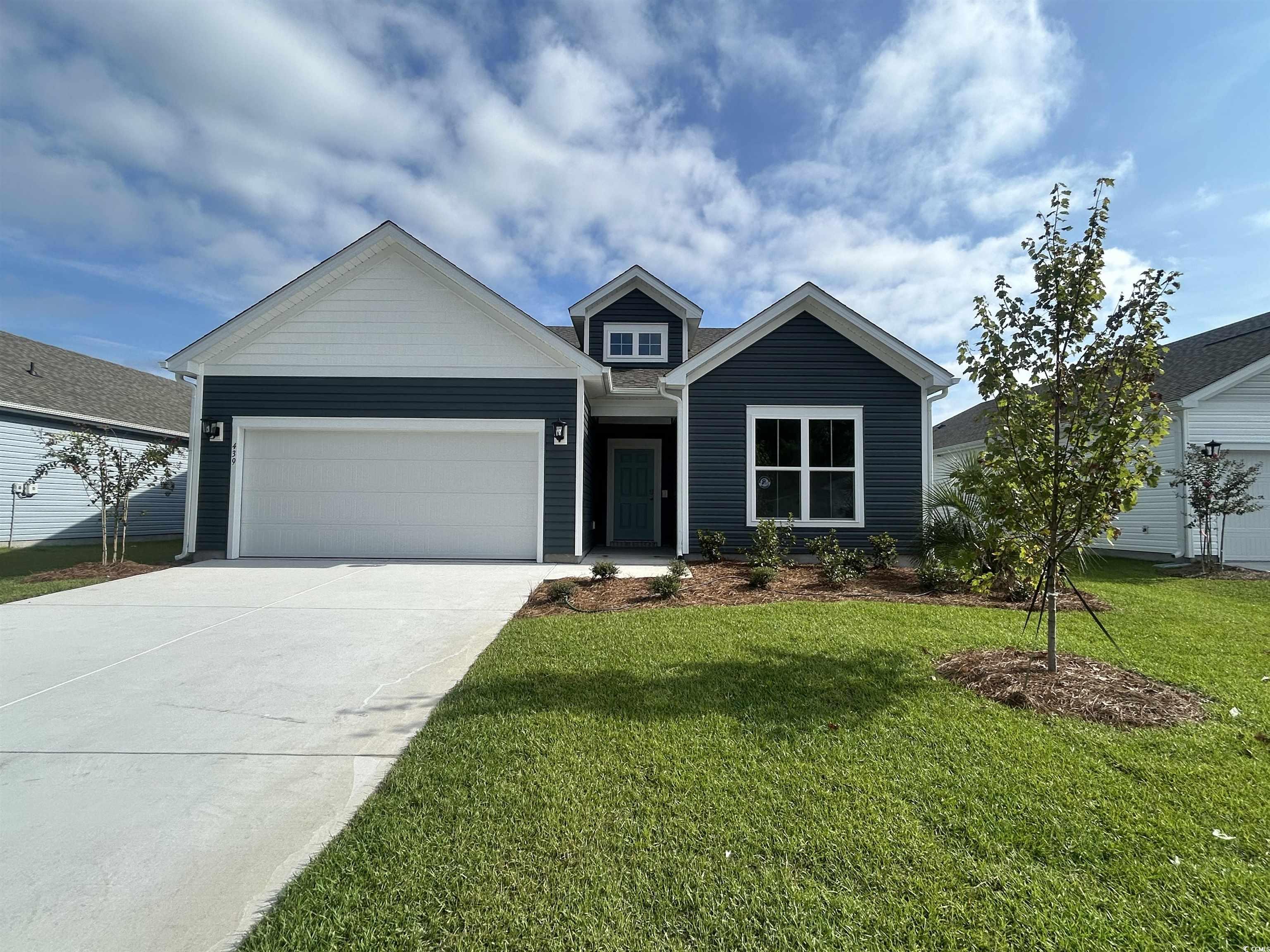 Ranch-style home with concrete driveway, a garage, and a front yard