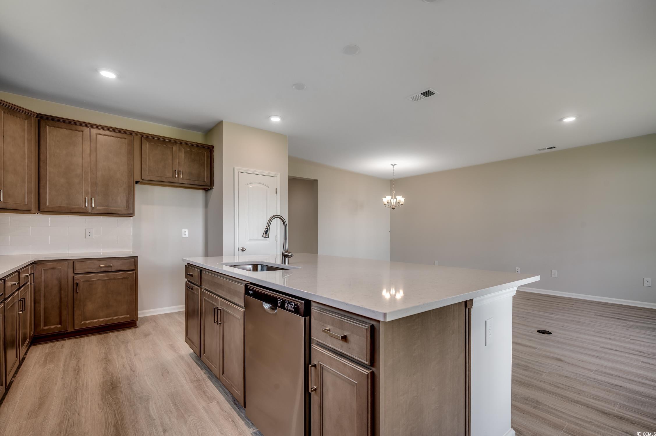 439 Kapalua Loop Little River, SC 29566 - Photo 14 of 36 Kitchen featuring light wood-style floors, dishwasher, recessed lighting, an island with sink, and light stone countertops