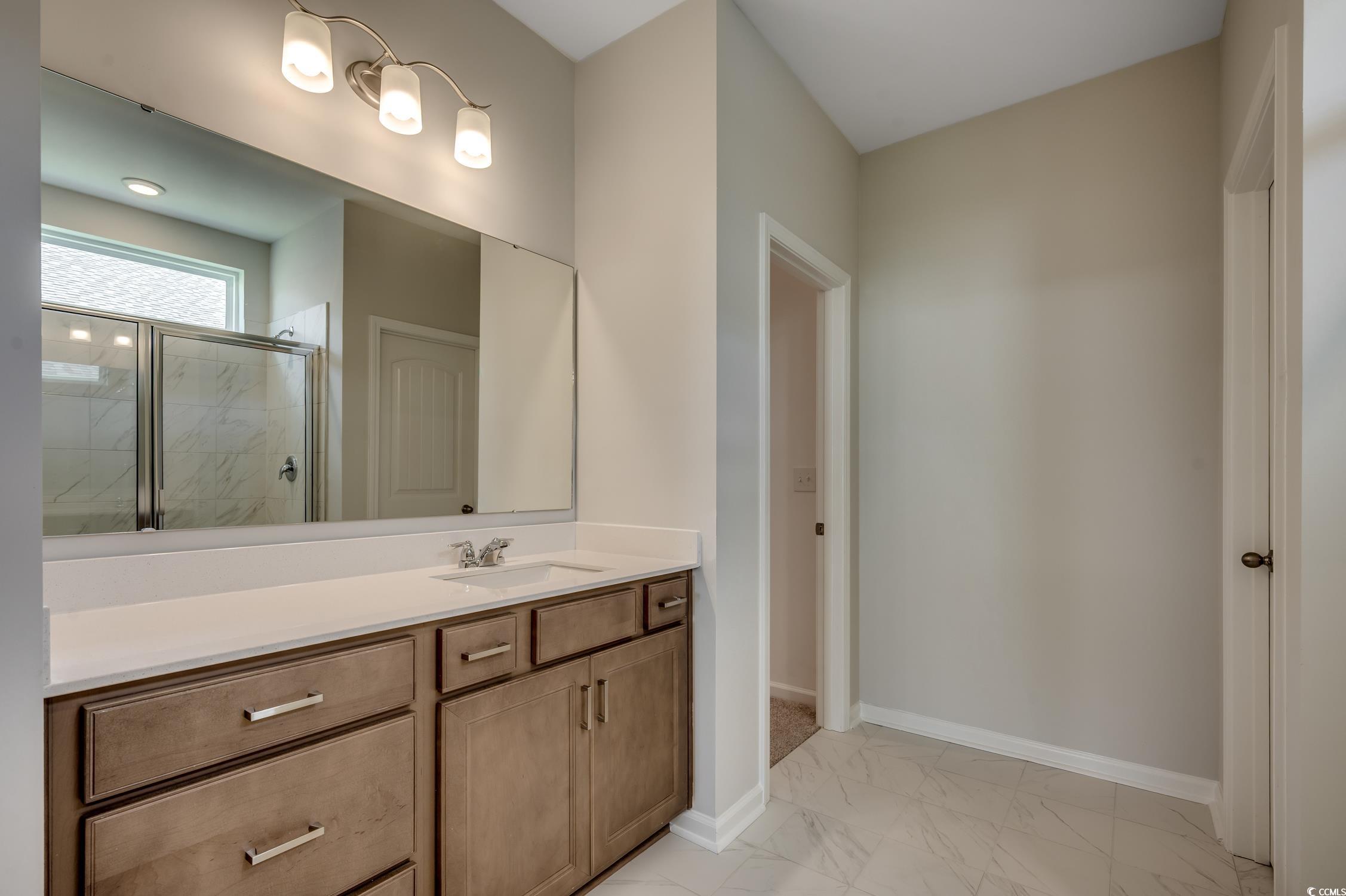 439 Kapalua Loop Little River, SC 29566 - Photo 24 of 36 Bathroom featuring a marble finish shower, vanity, and light marble finish flooring