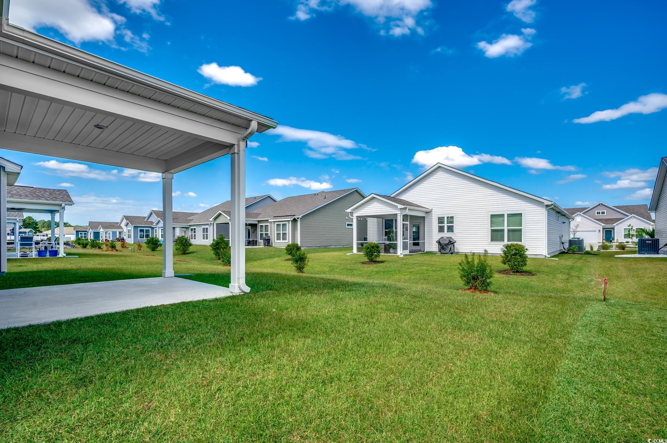 439 Kapalua Loop Little River, SC 29566 - Photo 32 of 36 Rear view of property with a yard, a residential view, and a patio