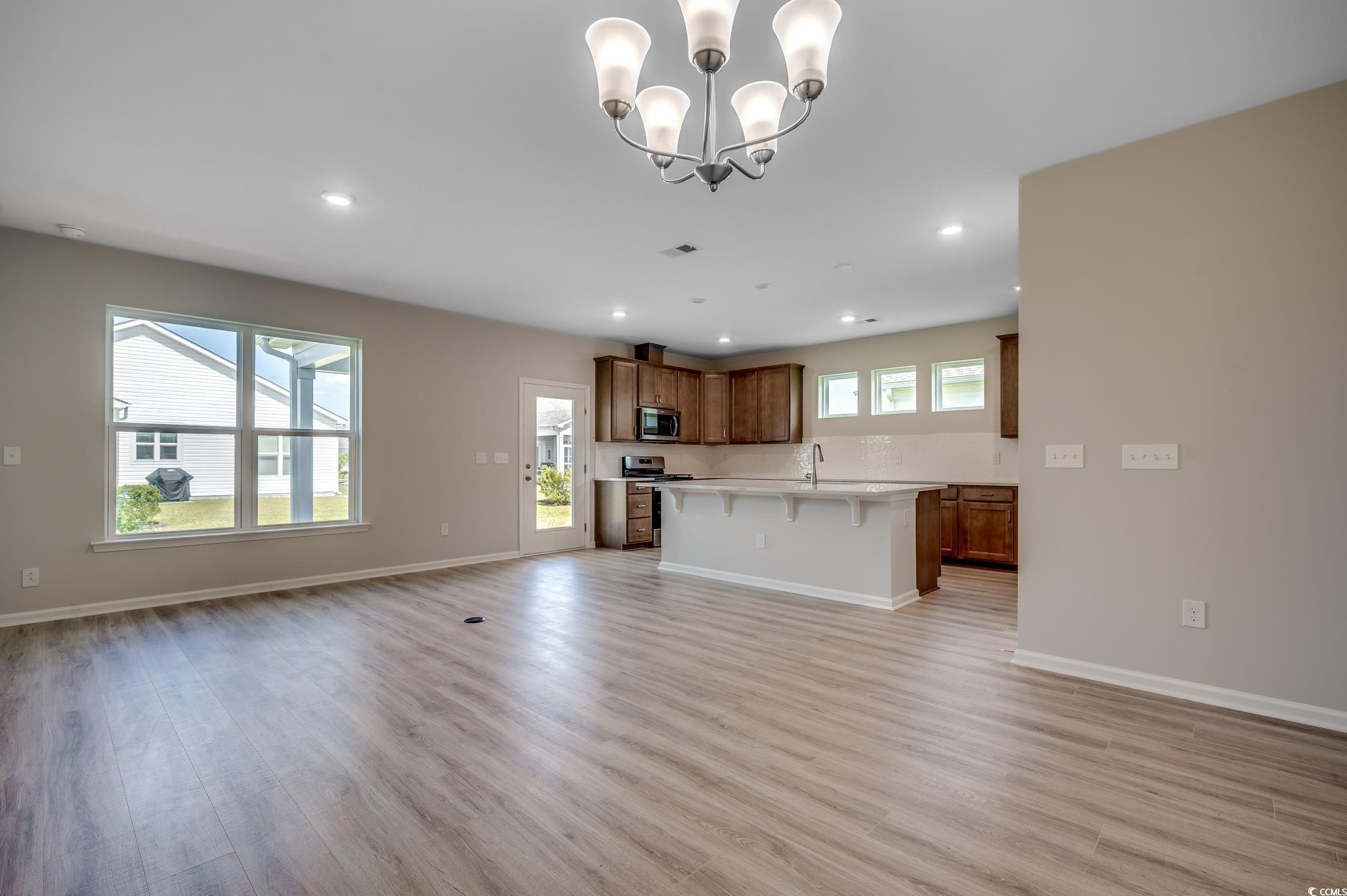 439 Kapalua Loop Little River, SC 29566 - Photo 8 of 36 Unfurnished living room featuring light wood-style floors, a chandelier, and recessed lighting