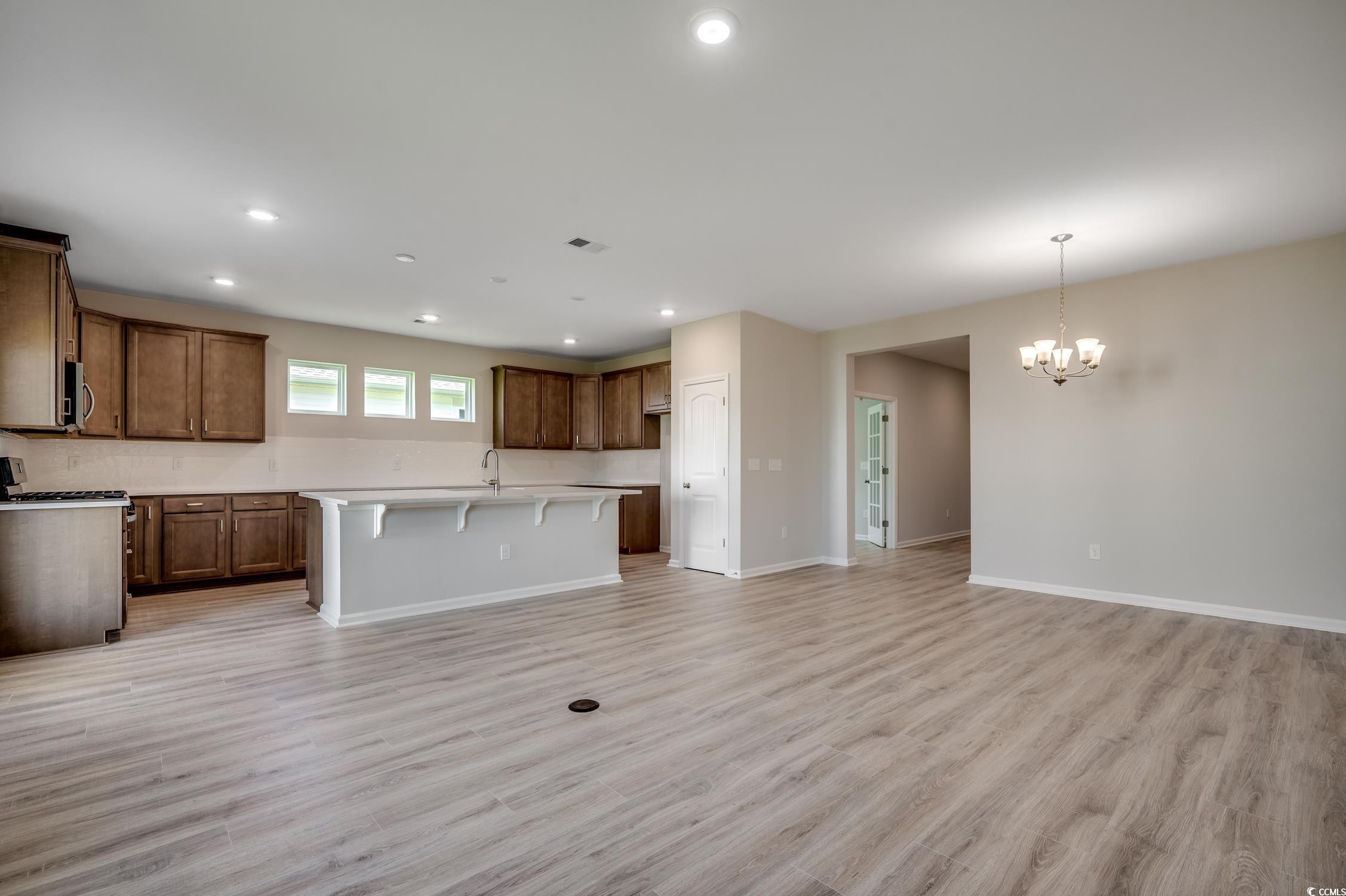 439 Kapalua Loop Little River, SC 29566 - Photo 9 of 36 Unfurnished living room with light wood-type flooring, recessed lighting, and a chandelier