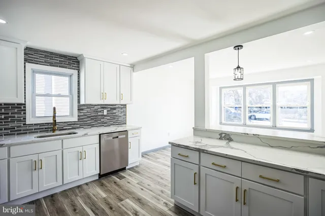 a bathroom with a granite countertop sink mirror and a window