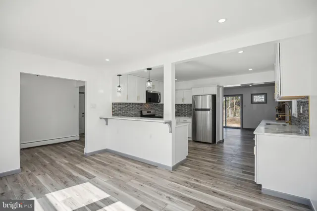 a kitchen with cabinets and wooden floor