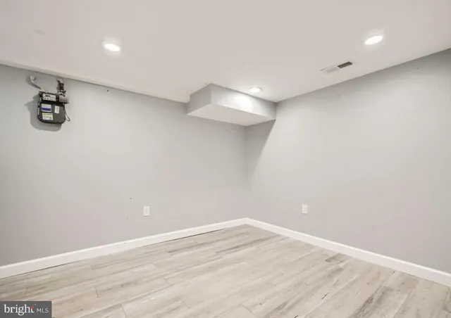 a view of a room with wooden floor and white walls