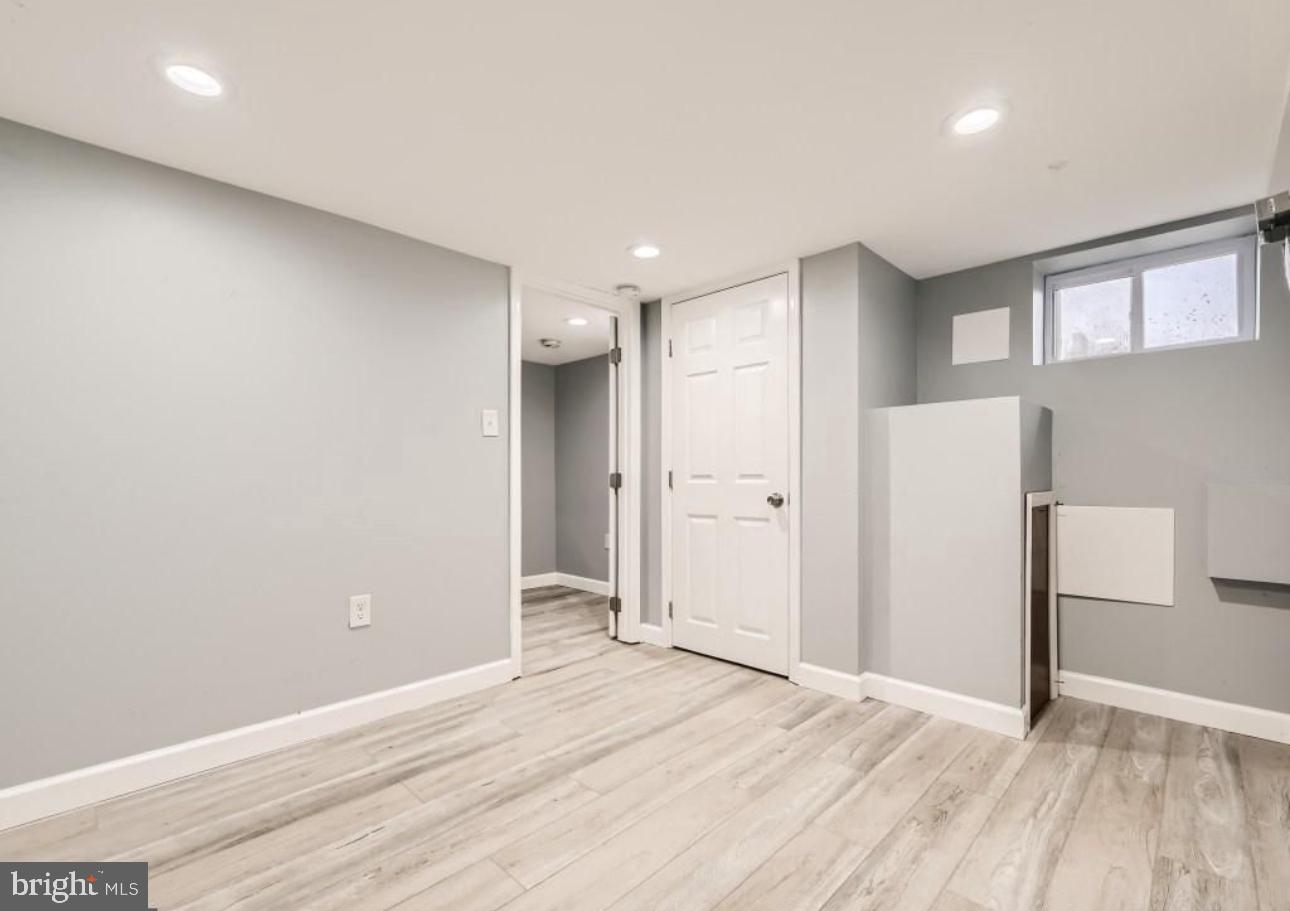 905 East Patapsco Avenue Baltimore, MD 21225 - Photo 18 of 25 a view of an empty room with wooden floor and a kitchen