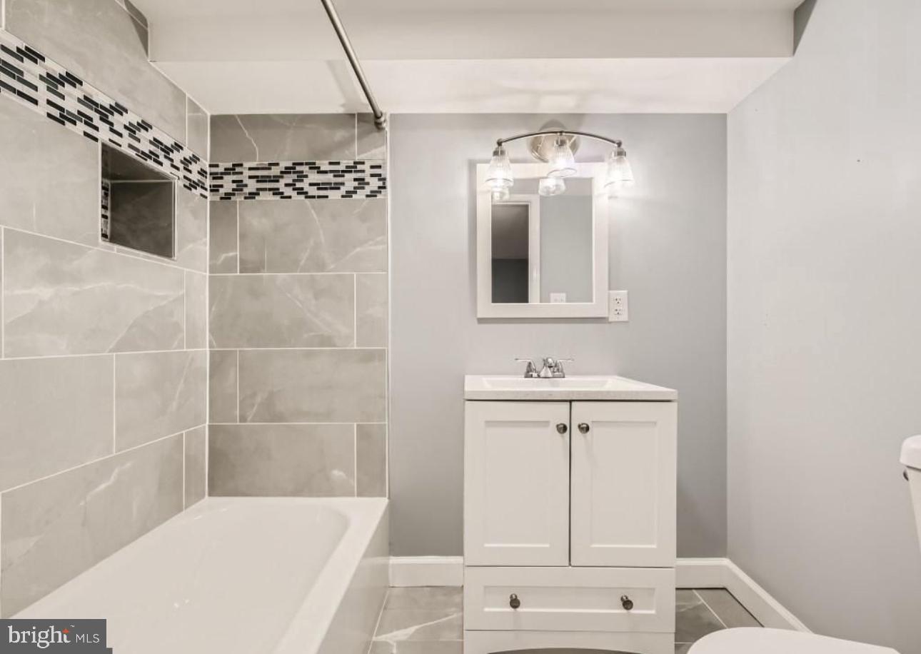 905 East Patapsco Avenue Baltimore, MD 21225 - Photo 19 of 25 a bathroom with a mirror sink and vanity