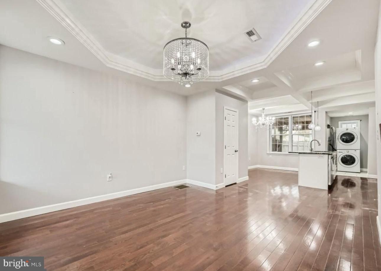 905 East Patapsco Avenue Baltimore, MD 21225 - Photo 25 of 25 an empty room with wooden floor chandelier and windows