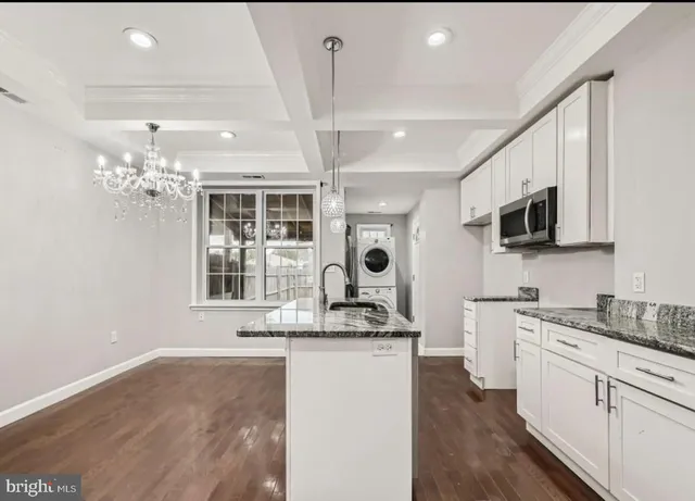 a kitchen with granite countertop a sink stainless steel appliances and cabinets