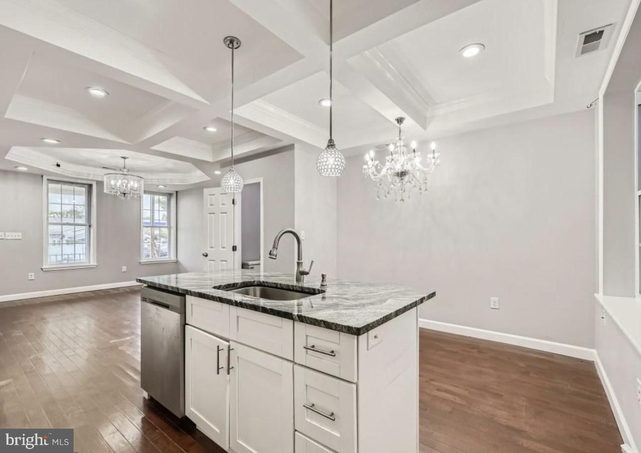 905 East Patapsco Avenue Baltimore, MD 21225 - Photo 8 of 25 a kitchen with a sink chandelier and wooden floor