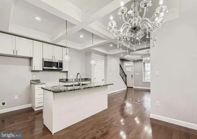 a kitchen with stainless steel appliances granite countertop a sink a stove and a refrigerator