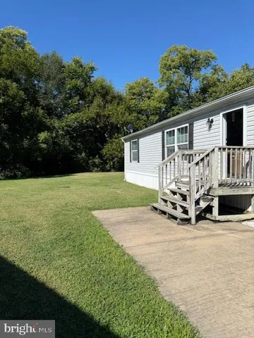 a view of a house with porch and a yard