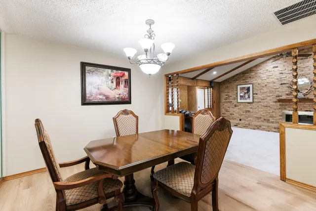 a view of a dining room with furniture wooden floor and chandelier