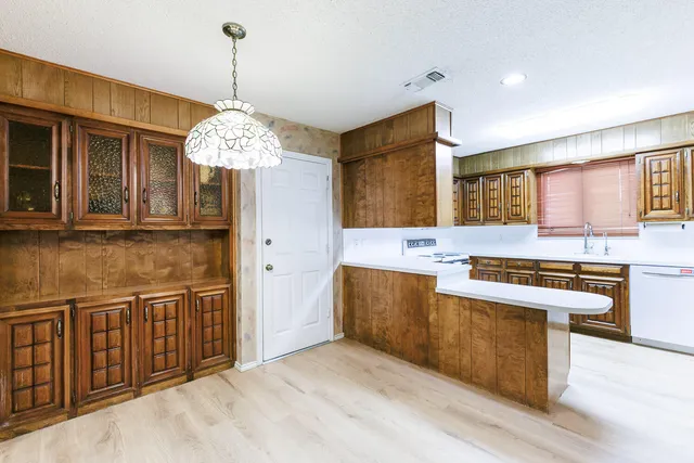 a view of a hallway with wooden floor and chandelier