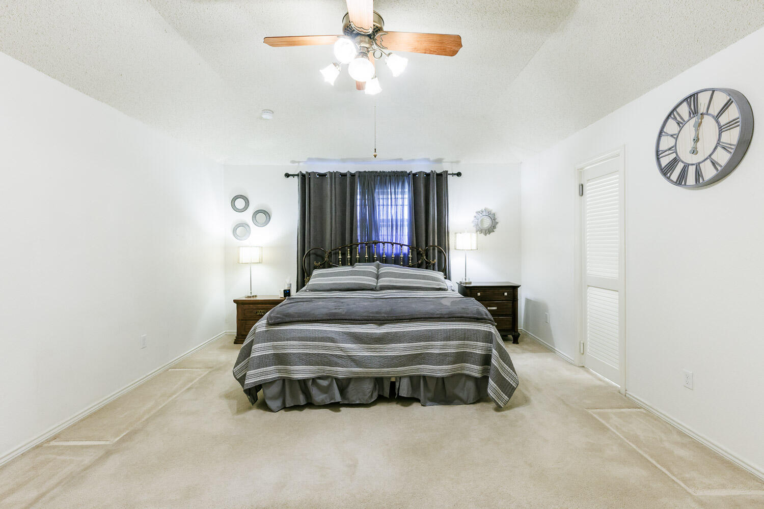 5717 72nd Street Lubbock, TX 79424 - Photo 24 of 54 a spacious bedroom with a bed and a chandelier