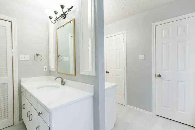 a bathroom with a granite countertop sink and a mirror