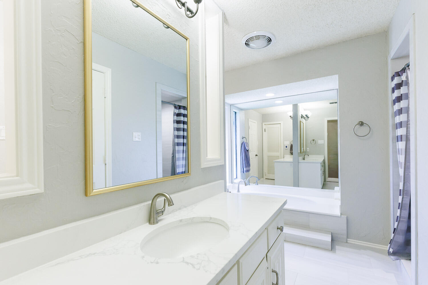 5717 72nd Street Lubbock, TX 79424 - Photo 31 of 54 a bathroom with a granite countertop sink and a mirror