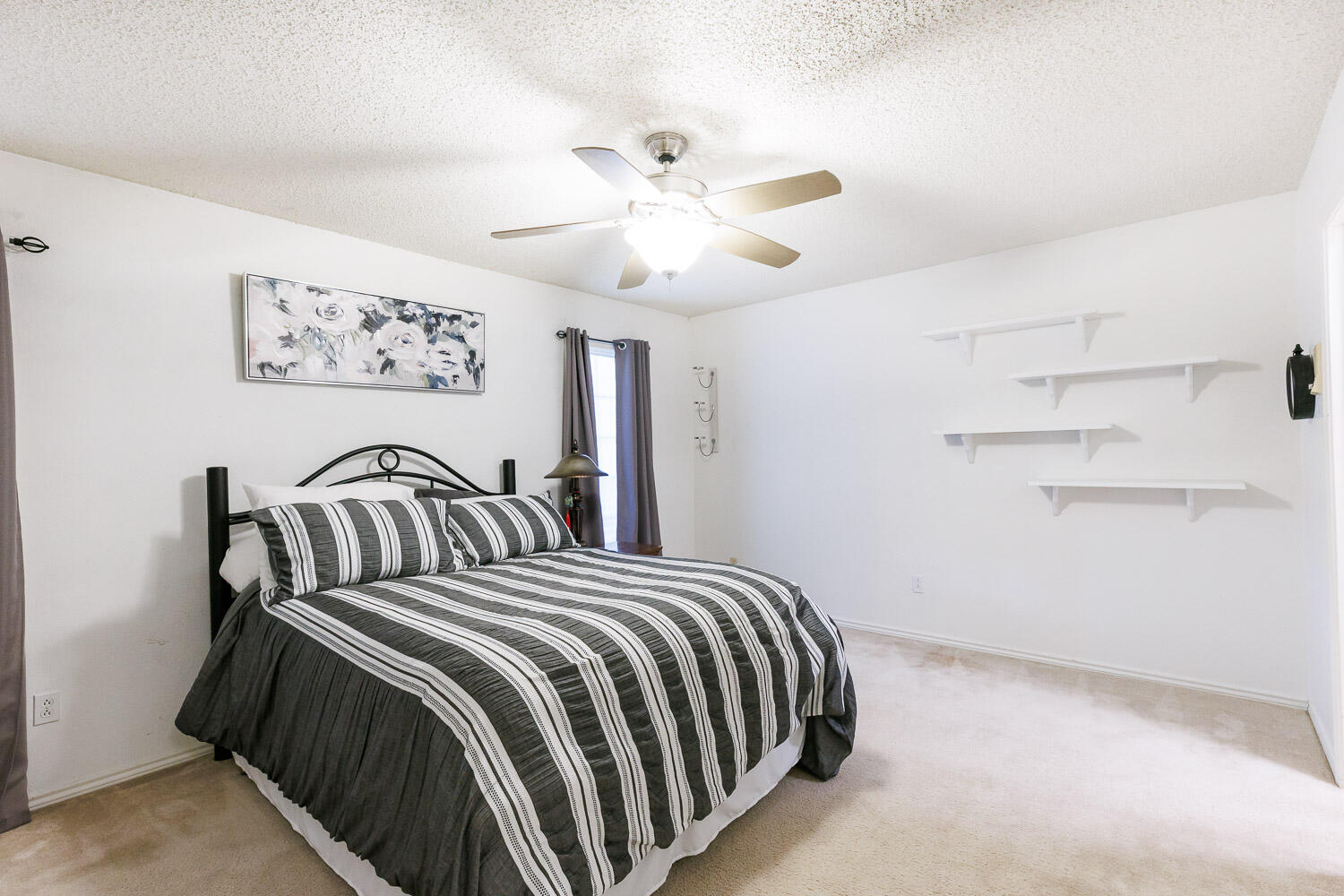5717 72nd Street Lubbock, TX 79424 - Photo 32 of 54 a bedroom with a bed and a chandelier