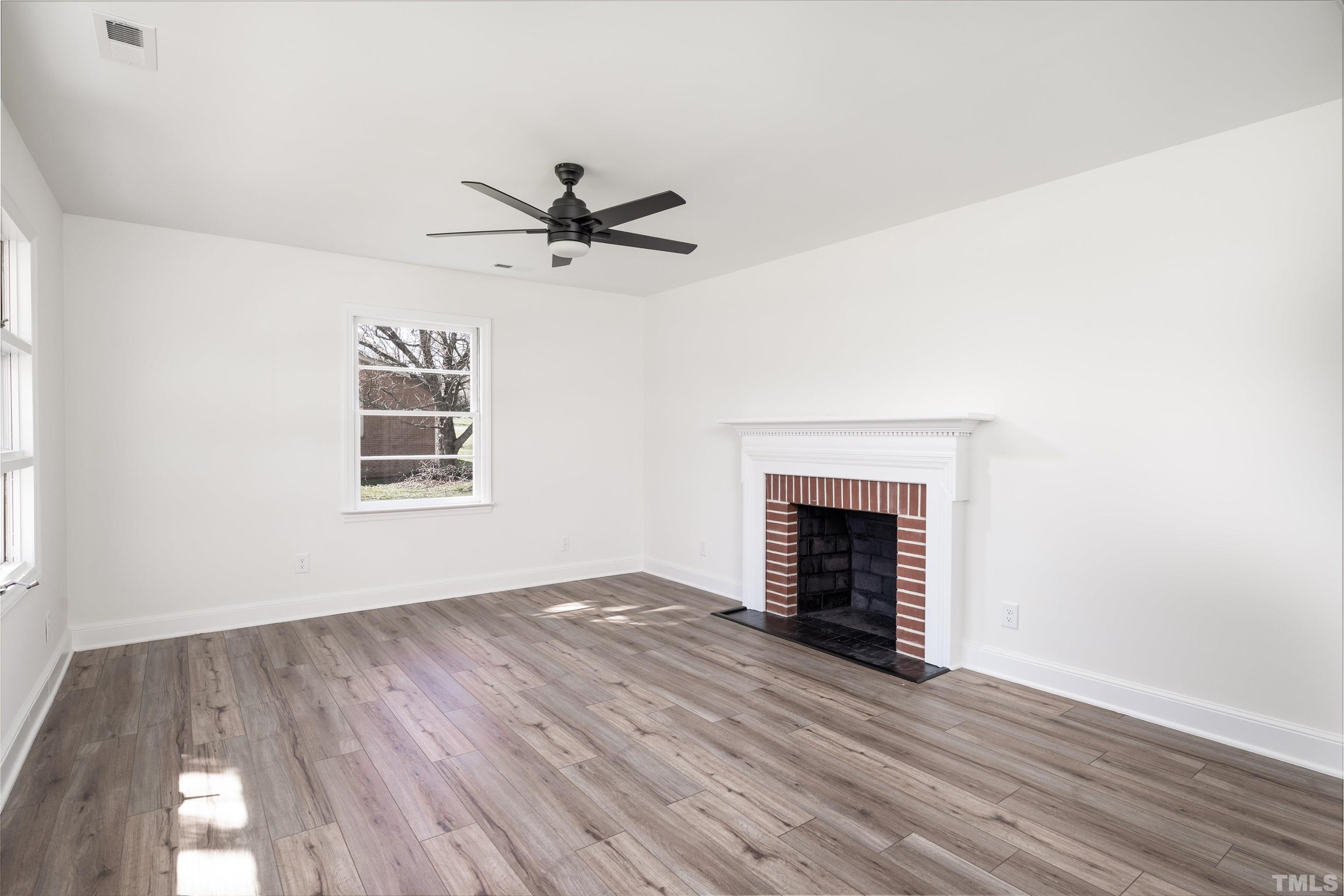3555 Boston Road Roxboro, NC 27573 - Photo 6 of 21 a view of empty room with wooden floor and fireplace