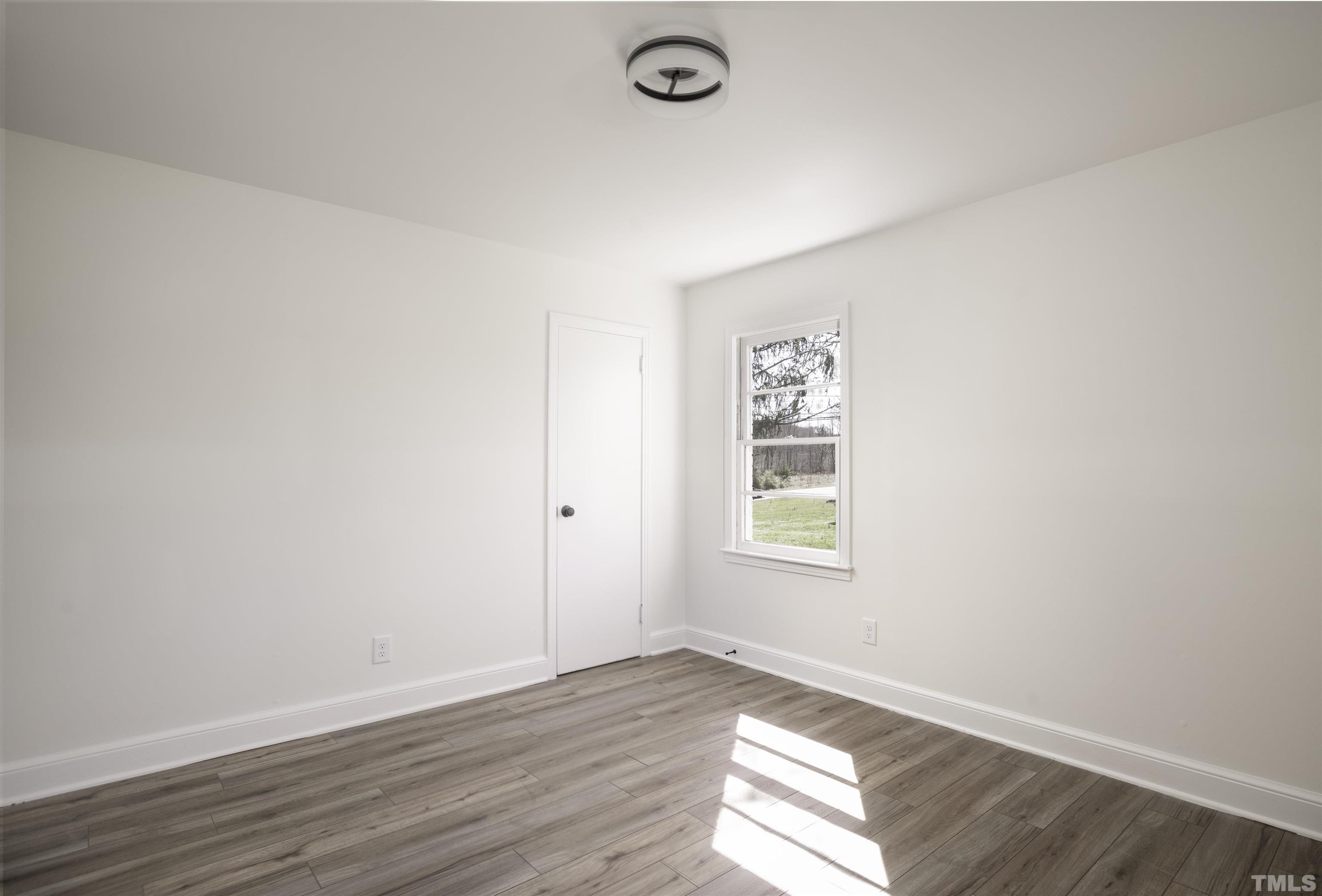 3555 Boston Road Roxboro, NC 27573 - Photo 8 of 21 an empty room with wooden floor and windows