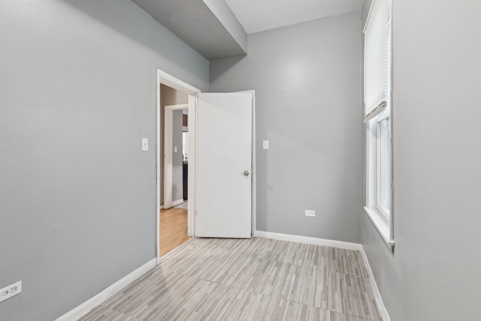 5756 South Princeton Avenue Chicago, IL 60621 - Photo 13 of 31 a view of an empty room with wooden floor and a window