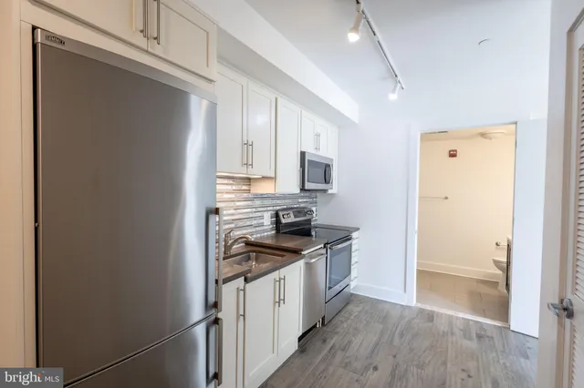 a kitchen with stainless steel appliances a refrigerator stove and sink