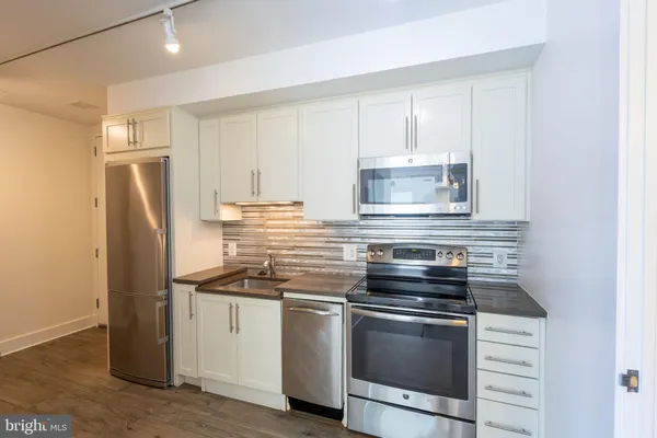 a kitchen with appliances cabinets and a counter top space