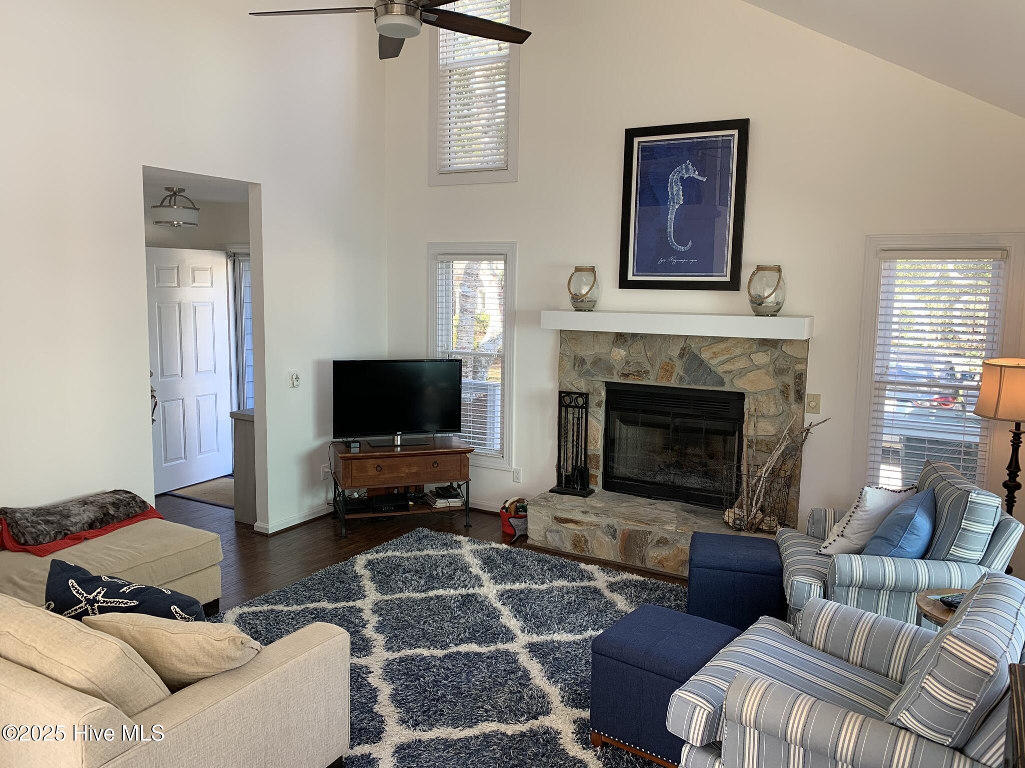 213 Sandfiddler East Emerald Isle, NC 28594 - Photo 11 of 44 Living room with vaulted ceilings and wood burning fireplace