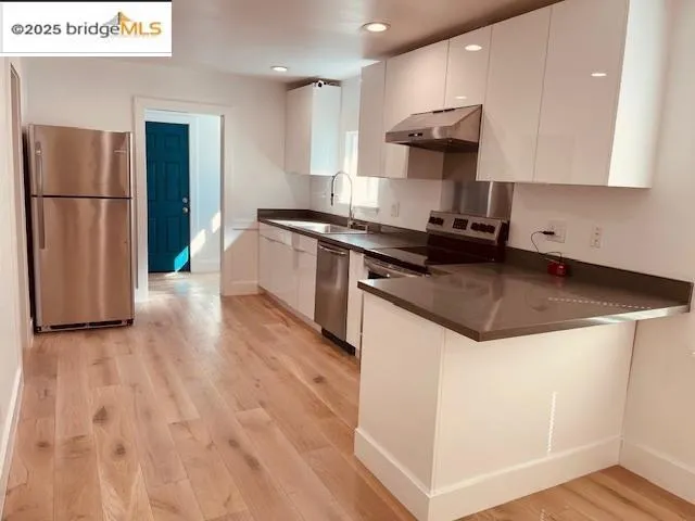 a kitchen with stainless steel appliances granite countertop a stove a refrigerator and a microwave