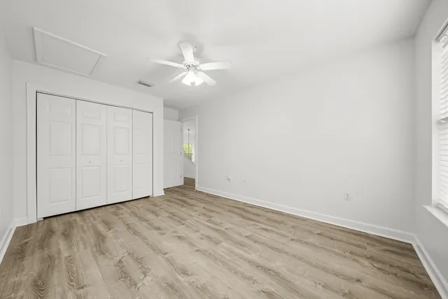 a view of an empty room with wooden floor