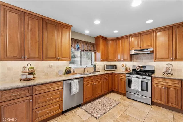 a kitchen with stainless steel appliances granite countertop wooden cabinets a sink and dishwasher