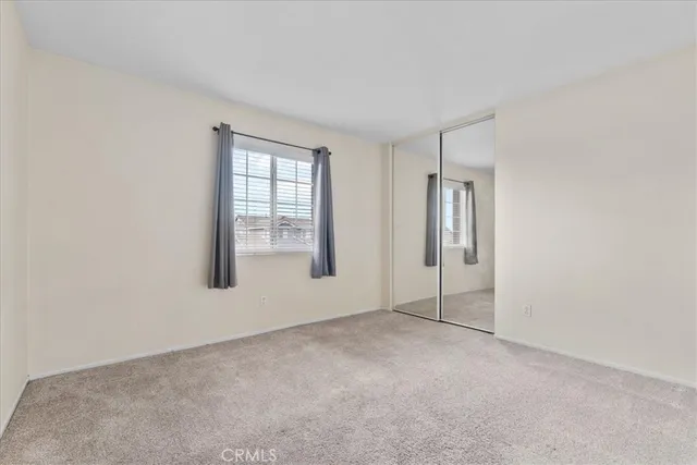 an empty room with windows and closet