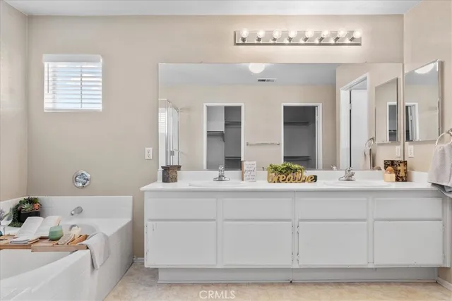 a bathroom with a bathtub a sink and a mirror